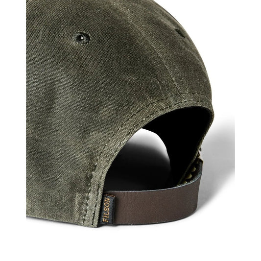 Close-up of the Filson Waxed Logger Cap in Otter Green showing the adjustable strap and fabric texture.