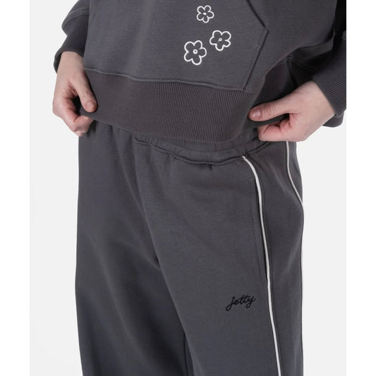 Charcoal Jetty Womens Grace Lounge Pants with white side stripe, model adjusting waistband.