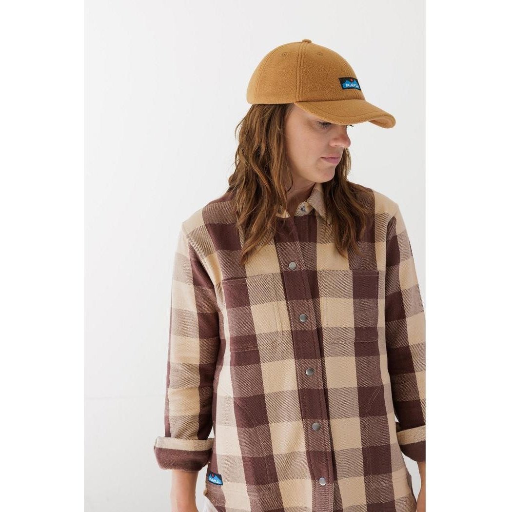A model wears the Kavu Toasty Topper Blackout hat with a brown brim and blue logo, shown from the front against a plain white background.