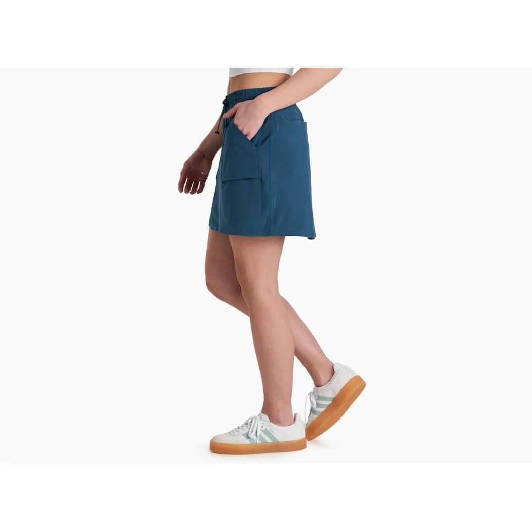 Side view of the Kuhl Women's Vantage Skort in Seaport showing the front pocket and white sneakers against a white background.