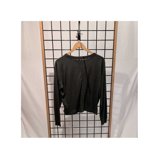 Back view of the Prana Womens Cozy Up LS Crew-SAMPLE in Nori hanging on a wooden hanger against a grid wall.