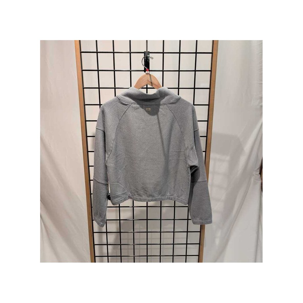 Back view of the Prana Womens Olivia LS-SAMPLE in Quarry hanging on a wooden hanger against a grid background.