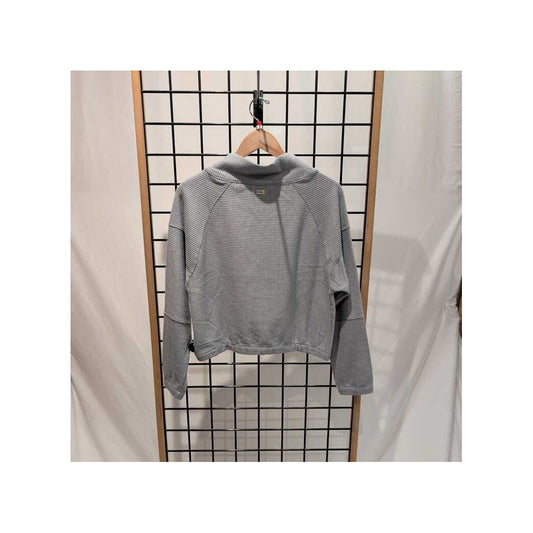 Back view of the Prana Womens Olivia LS-SAMPLE in Quarry hanging on a wooden hanger against a grid background.