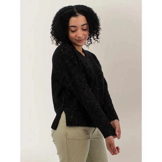 Side view of the Aventura Womens Elsa Sweater in Meteorite on a model wearing beige pants against a white background.
