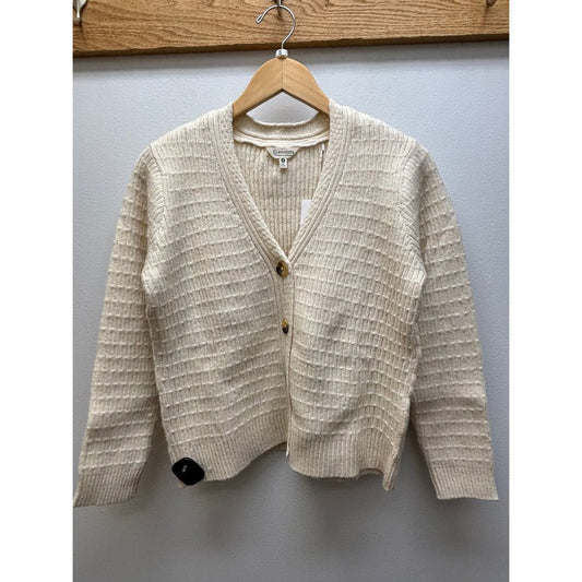 Front view of the Aventura Women's Snug Hollow Cardigan in HeatheredOatmea hanging on a wooden hanger against a light gray wall.