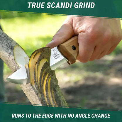 A hand holds the Beavercraft BSH2 Bushcraft Knife cutting through wood outdoors, showing the True Scandi grind feature.