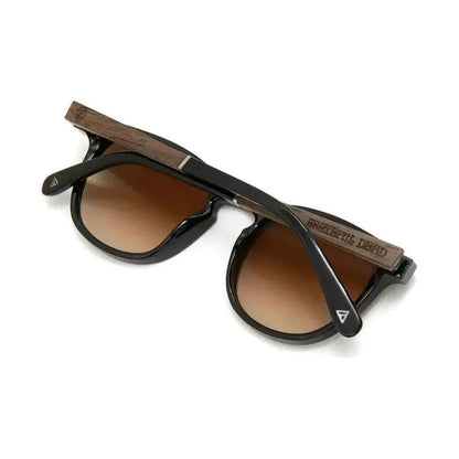 Side view of the Camp Eyewear Topo: Grateful Dead Stealie Edition sunglasses with black frames and brown lenses, showing the engraved Stealie on the temple against a white background.