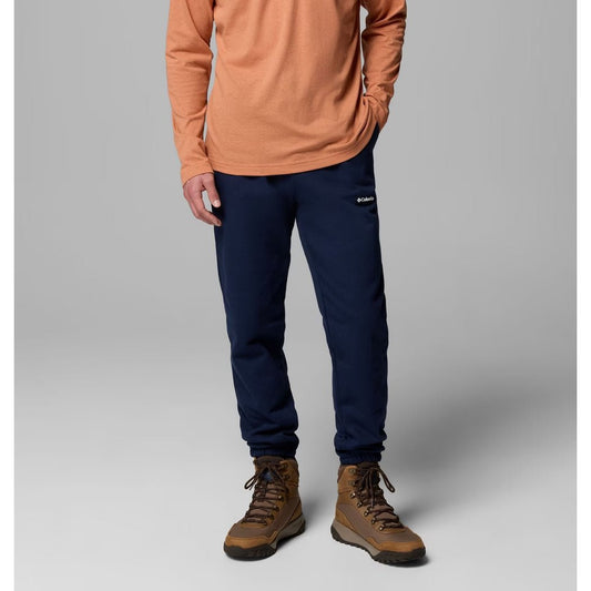 Front view of the Columbia Sportswear Men's Oakwind Jogger in 464CollegiaNavy with a model wearing brown boots against a gray background.