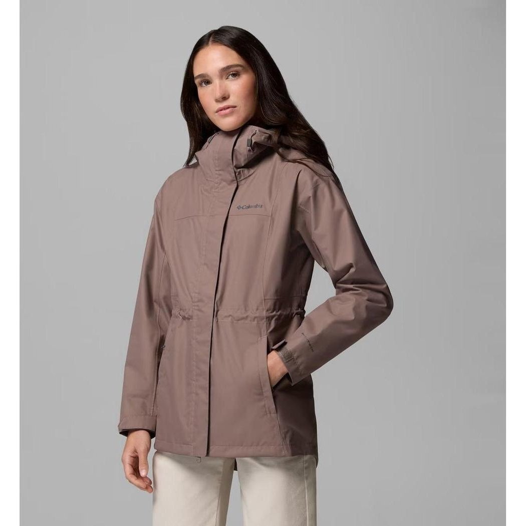 A woman models the Columbia Sportswear Women's Hikebound II Long Jacket in Iron, showing the front with a high collar and pockets, against a plain gray background.