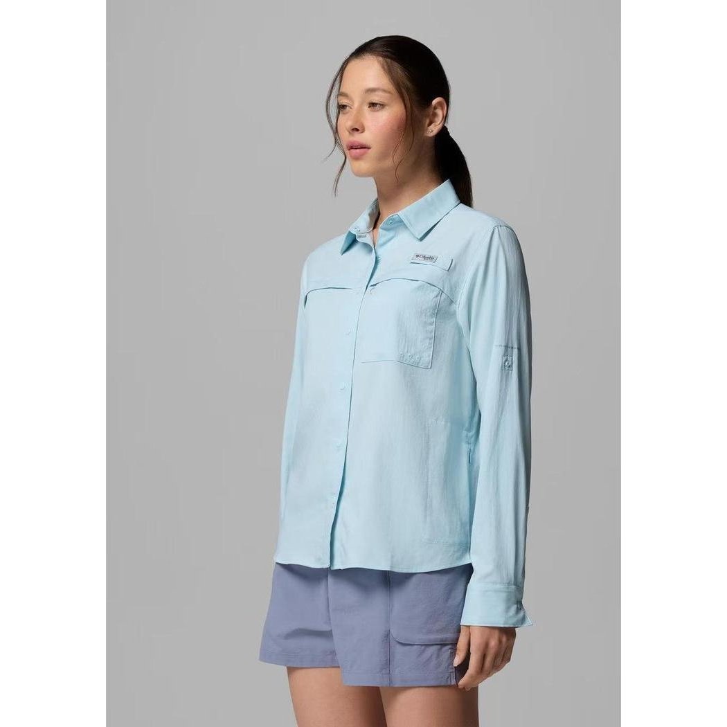 A side view of the Columbia Sportswear Women's PFG Castback Woven Long Sleeve in Marine Light shows the front pocket and collar against a gray background.