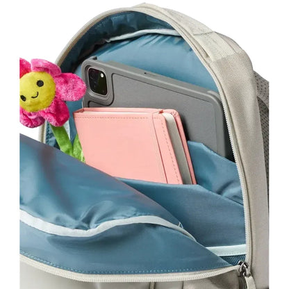 Back view of the Cotopaxi Allpa 18L Daypack in Mineral showing the front pocket with a phone, notebook, and a stuffed flower inside.