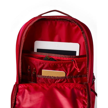 Front view of the Cotopaxi Allpa 26L Daypack in Blue Spruce/Abyss showing its red interior and organized compartments.