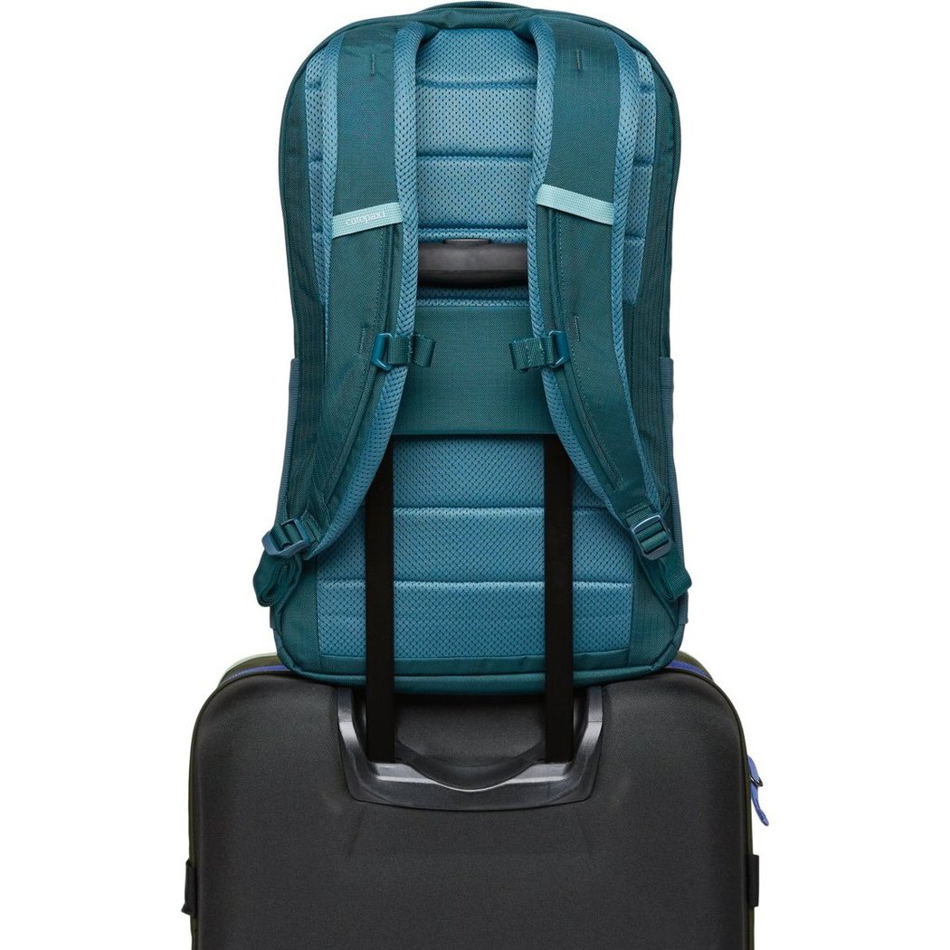 Back view of the Cotopaxi Allpa 26L Daypack in Blue Spruce/Abyss resting on a black suitcase.