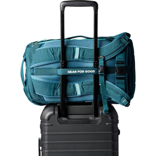 Back view of the Cotopaxi Allpa 28L Travel Pack in Blue Spruce/Abyss attached to a black suitcase handle.