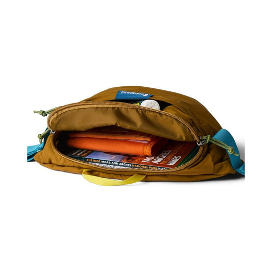 Open view of the Cotopaxi Empacable 3L Sling in Log Cabin showing its contents and blue straps.
