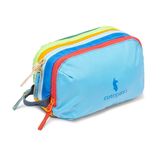 Front view of the Cotopaxi Nido Accessory Bag - Del Día in Del Día showing the colorful zippers and blue logo against a white background.