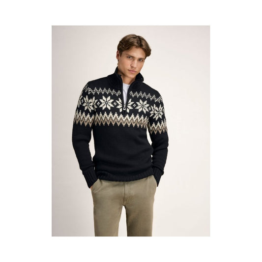 A model wearing the Dale Of Norway Myking Masc Sweater-SAMPLE in BlkBrwnOffWht stands against a plain background.