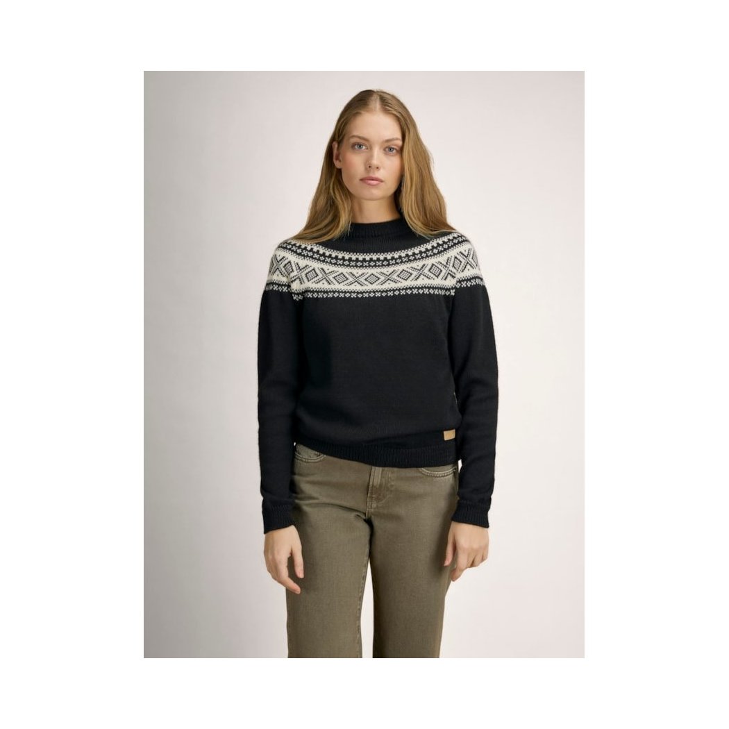 A model wearing the Dale Of Norway Vågsøy Feminine Sweater-SAMPLE in Black Offwhite stands against a plain background.