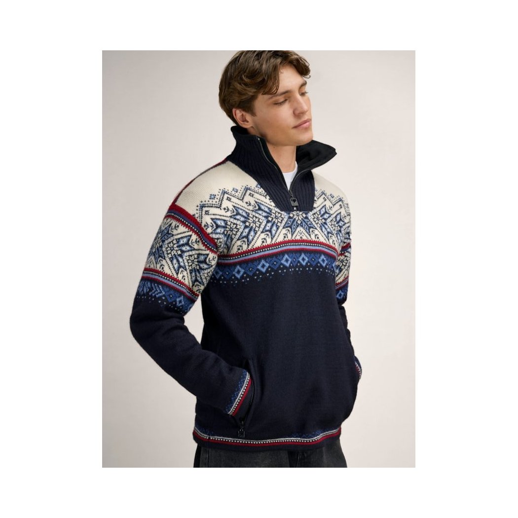A model wears the Dale Of Norway Vail Windproof Masc Sweater-SAMPLE in NavyRedOffWht with a high collar and patterned chest and sleeves.
