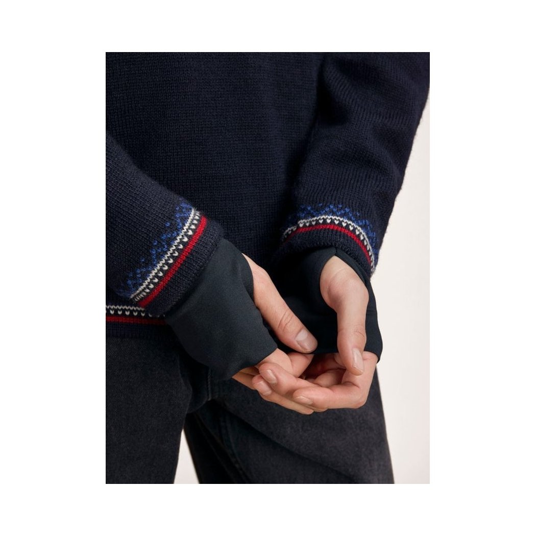 A close-up of the Dale Of Norway Vail Windproof Masc Sweater-SAMPLE in NavyRedOffWht, showing the patterned cuffs and hands clasped in front.