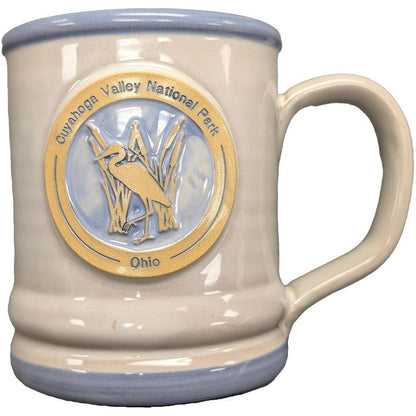 A side view of the Deneen Pottery Cuyahoga Valley National Park Mug showing the embossed heron logo against a white background.