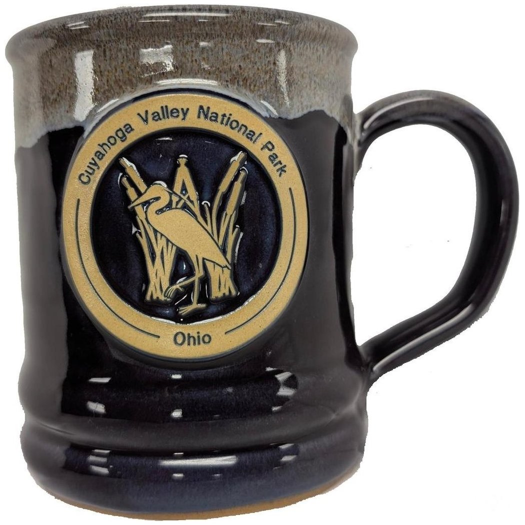 A front view of the Deneen Pottery Cuyahoga Valley National Park Mug in Forest color showing the logo and handle.