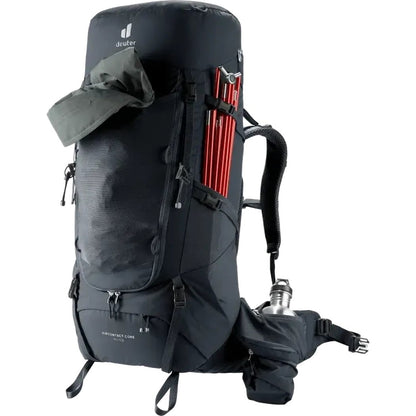Side view of the Deuter Aircontact Core 60+10 black backpack showing red trekking poles and a water bottle on the hip belt against a white background.