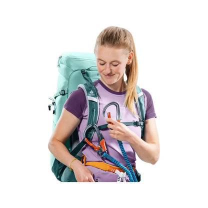Front view of the Deuter Trail 28 SL in Glacier Deep Se with a model adjusting climbing gear against a white background.