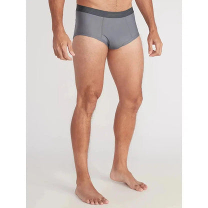 A front view of the Exofficio Men's Give-N-Go 2.0 Brief in Black on a barefoot model against a plain white background.