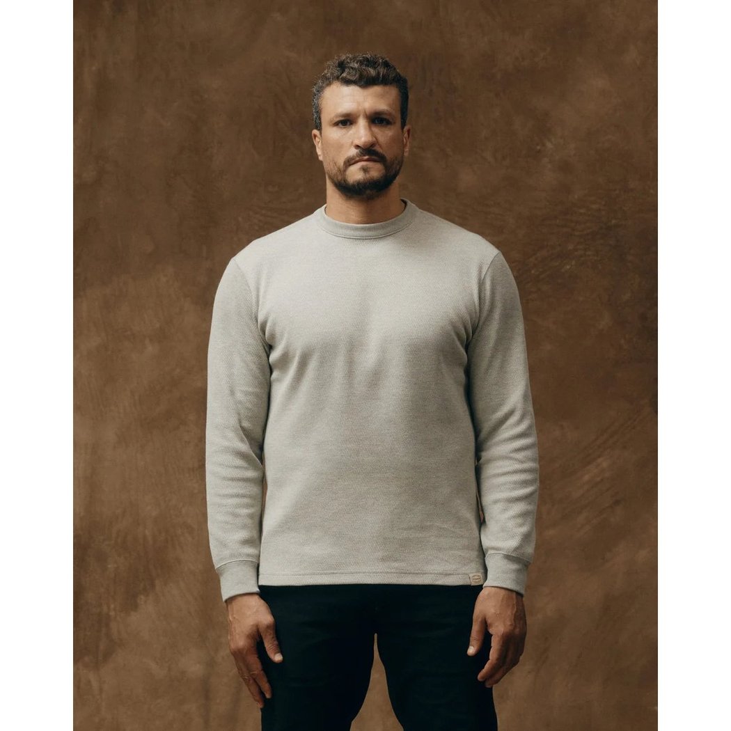 Front view of the Filson Men's Waffle Knit Thermal Crewneck in Charcoal on a model against a brown background.