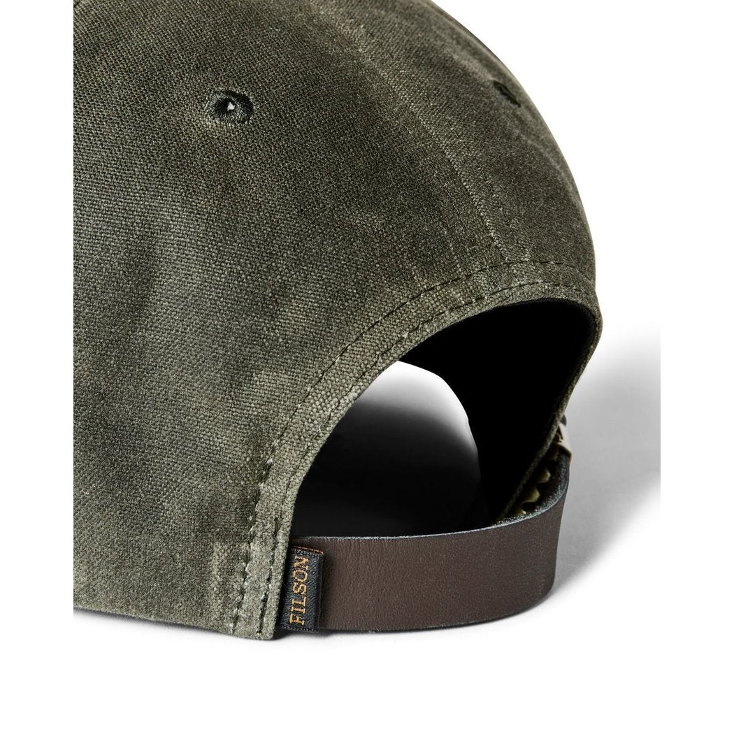 Close-up of the Filson Waxed Logger Cap in Otter Green showing the adjustable strap and fabric texture.