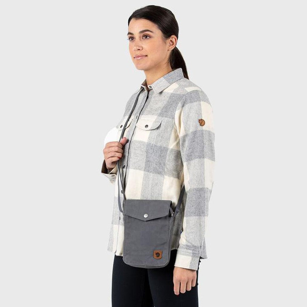 Side view of the Fjallraven Greenland Pocket bag in Black, worn by a model against a plain white background.
