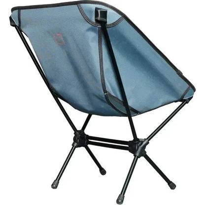 A side view of the Grand Trunk Caddis HD Chair in Storm Blue showing its foldable frame and black legs against a white background.
