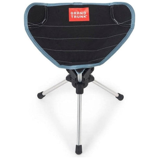 A front view of the Grand Trunk Compass 360 Stool in Black showing the tripod base and red Grand Trunk logo on the seat.
