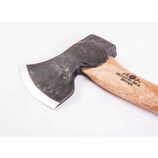 A left bevel Gransfors Bruk Swedish Carving Axe with a natural wooden handle and charcoal colored metal head, photographed from a side angle against a white background.