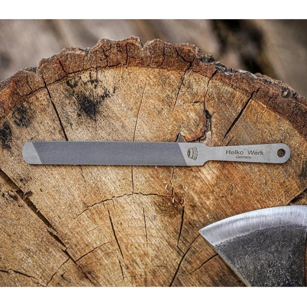 A Helko Werk Compact Sharpening File rests on a tree stump with an axe nearby.