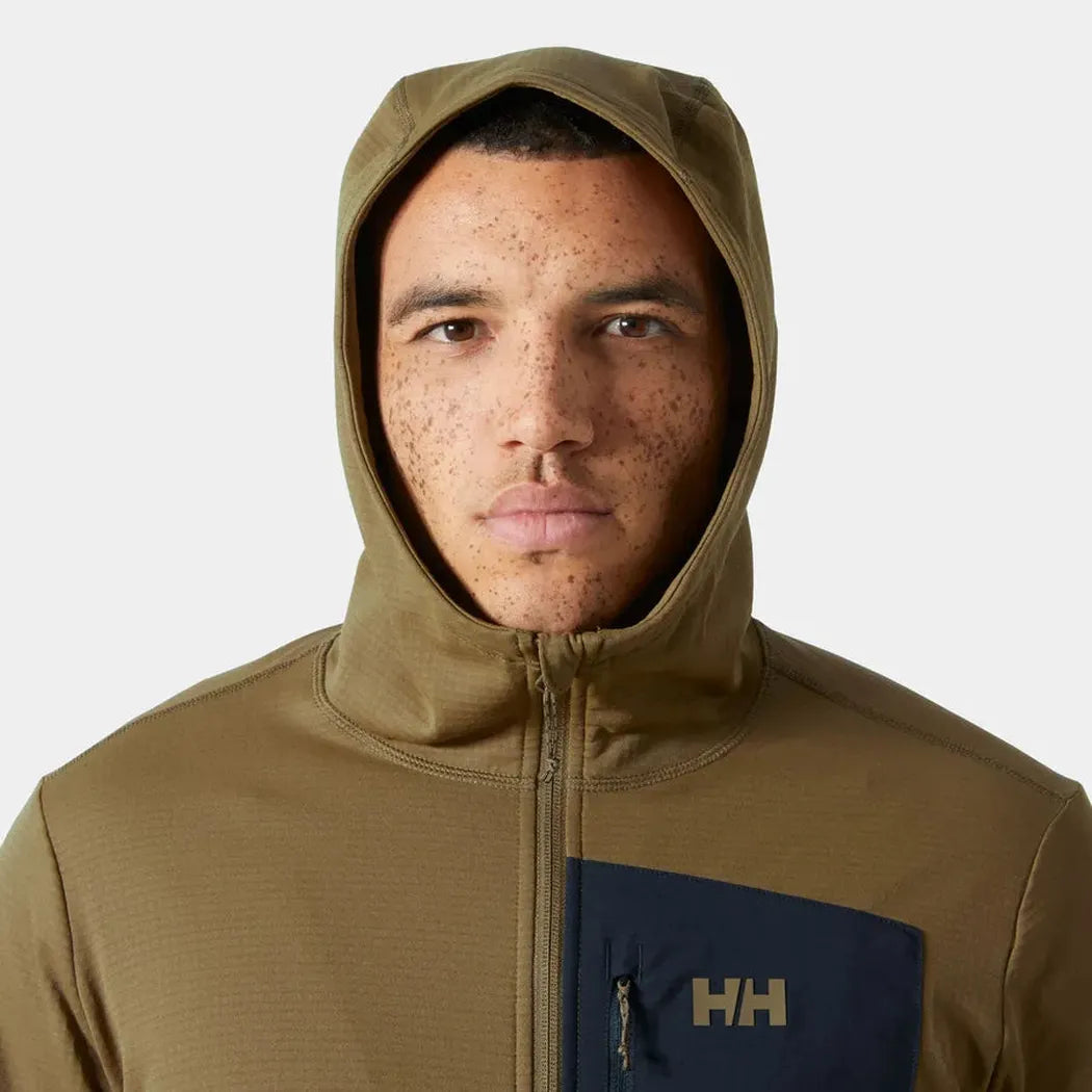 A front view of the Helly Hansen Men's Versalite Hooded Fleece Jacket in Sepia with a dark blue pocket patch and zipper, on a model against a plain white background.
