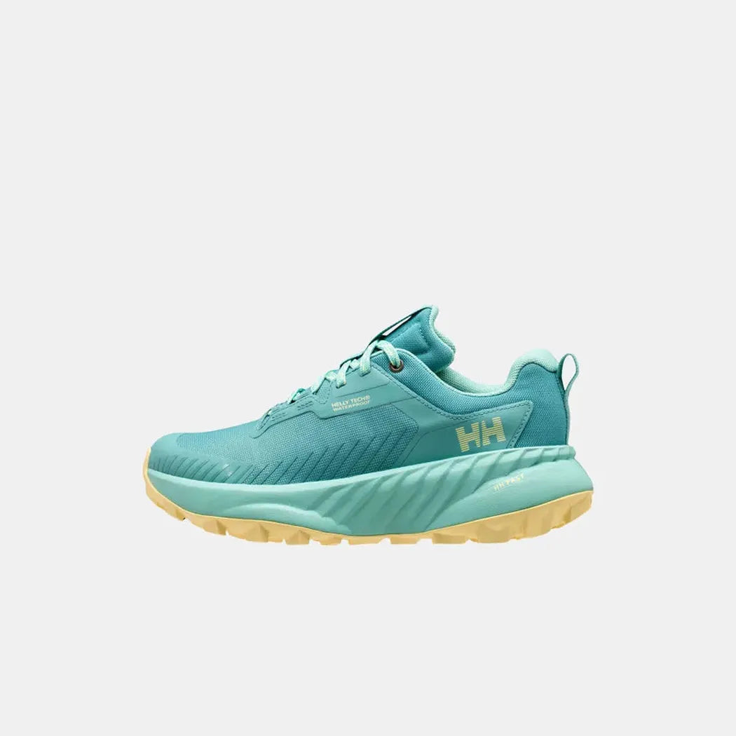 Side view of the Helly Hansen Women’s AWE Hiker HELLY TECH Shoes in Dark Mint / Yellow Pear with a thick yellow outsole against a white background.