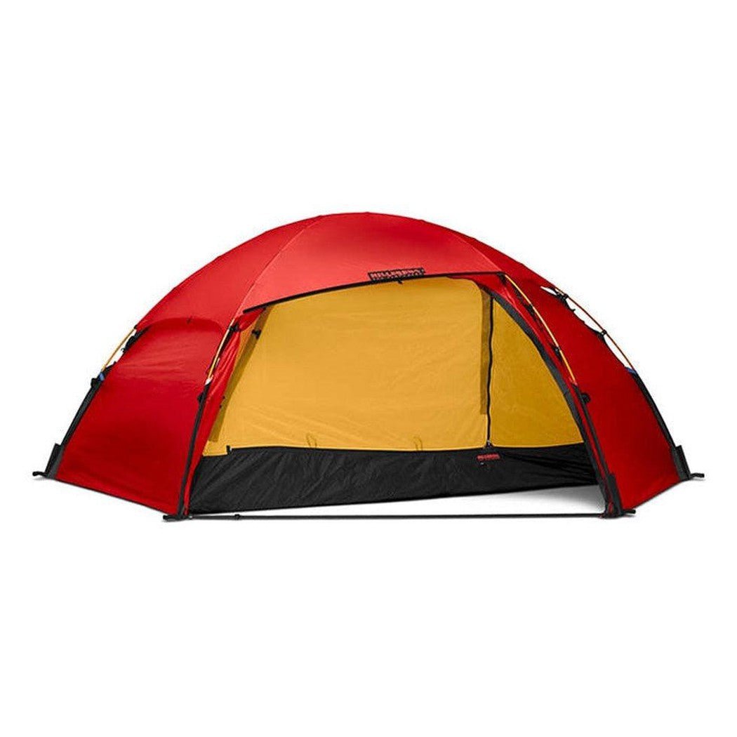 A red Hilleberg Allak 3 tent with a yellow interior and black floor, photographed from a front angle against a white background.