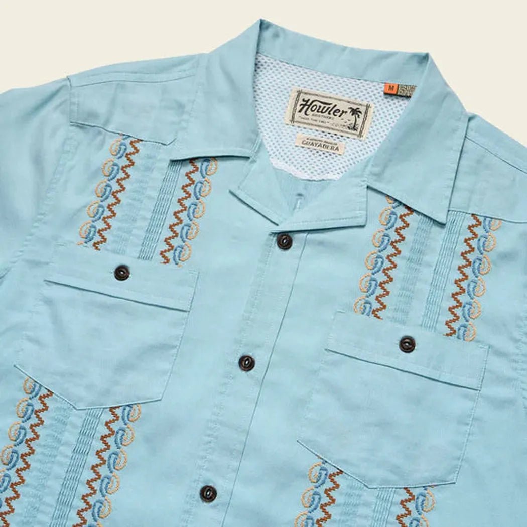 A close-up of the Howler Brothers Men's Guayabera Shirt in Nile Blue showing the embroidered details and button front against a light background.