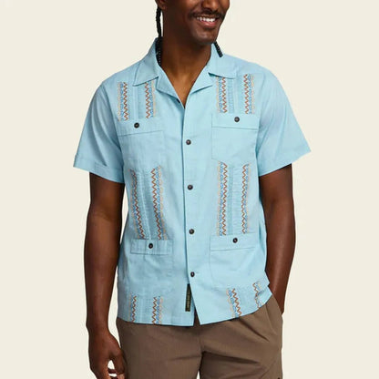 A front view of the Howler Brothers Men's Guayabera Shirt in Nile Blue showing the embroidered details and pockets against a plain background.