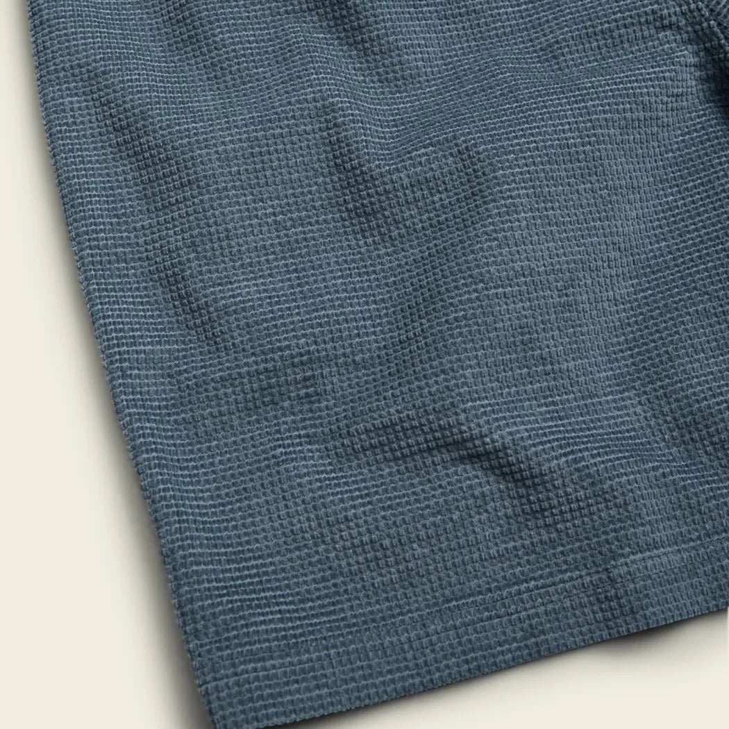 A close-up of the Howler Brothers Men's Pressure Drop Cord Shorts in Grid : Blue Mirage, showing the textured fabric and a light background.