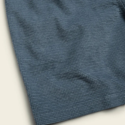 A close-up of the Howler Brothers Men's Pressure Drop Cord Shorts in Grid : Blue Mirage, showing the textured fabric and a light background.