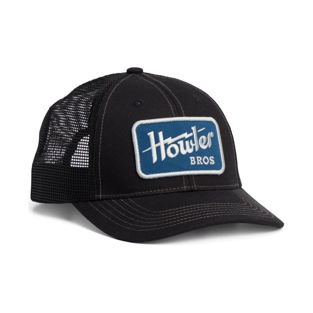 A front view of the Howler Brothers Standard Hat in El Sol Brown with a mesh back and a blue patch on the front, against a white background.