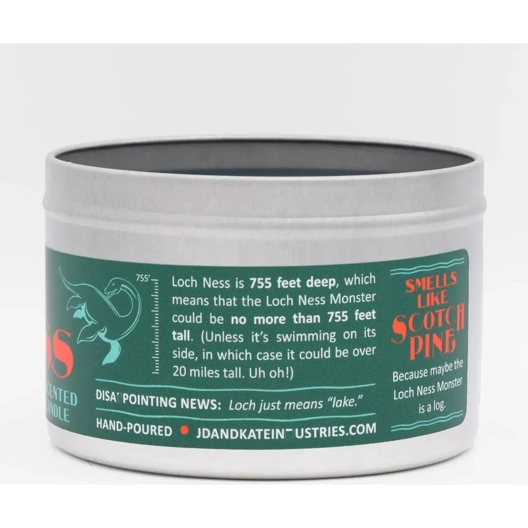 A front view of the JD and Kate Industries Loch Ness Monster Scented Candle showing the green label and white tin against a plain background.
