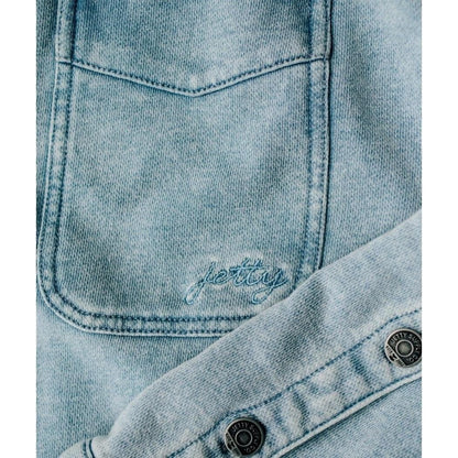 A close-up of the Jetty Women's Eden Knit Shirt in Denim showing the front pocket and button placket.