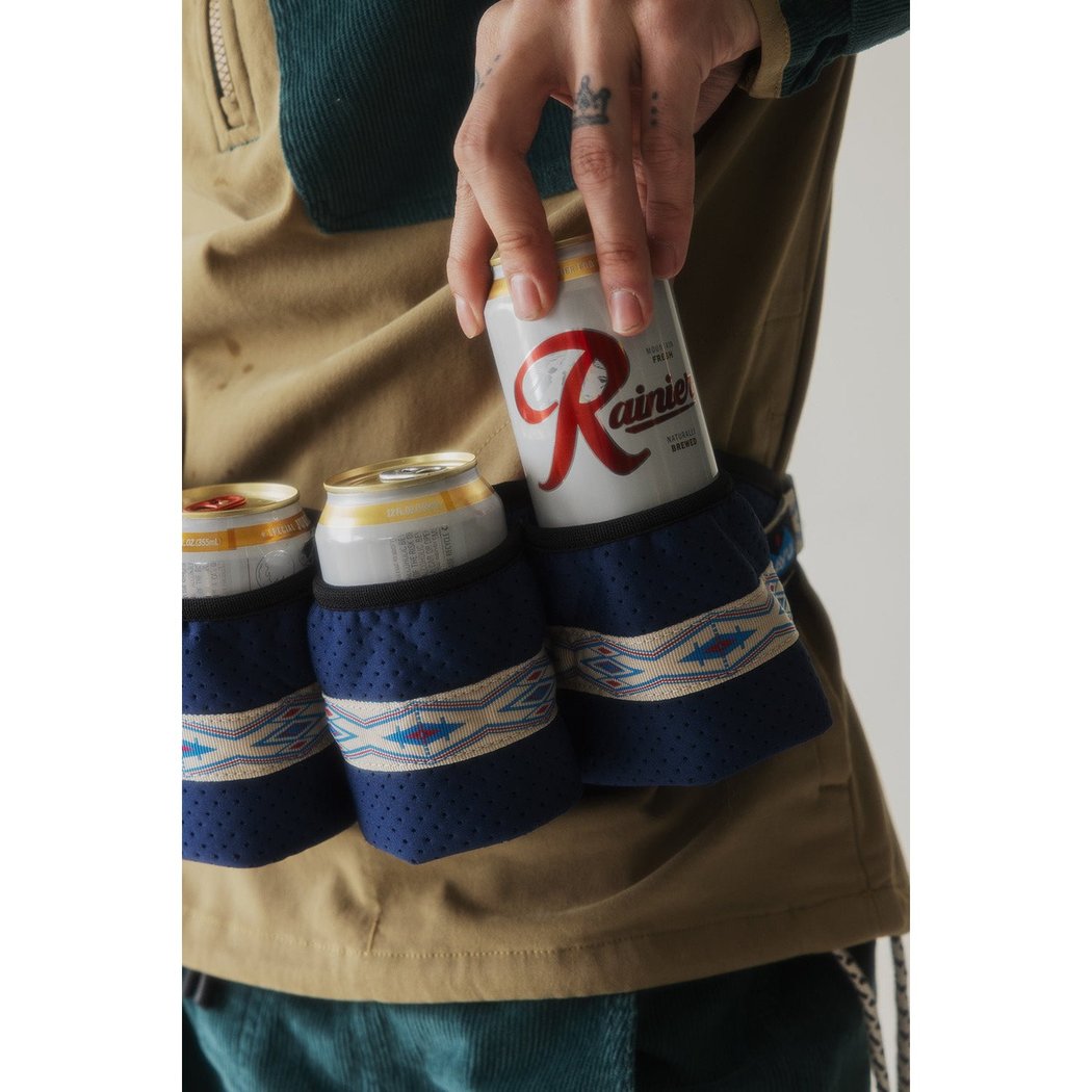 Close-up of the Kavu Beer Buddy in Park Lines holding three cans, with a hand reaching for the top one.