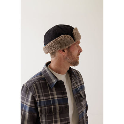 Side view of the Kavu Fur Ball Fudd in Moonless Night on a man wearing a plaid shirt against a white background.