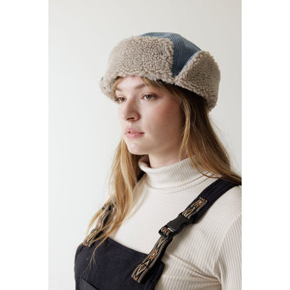 Side view of the Kavu Fur Ball Fudd in Moonless Night on a model with a white turtleneck and dark overalls against a plain background.