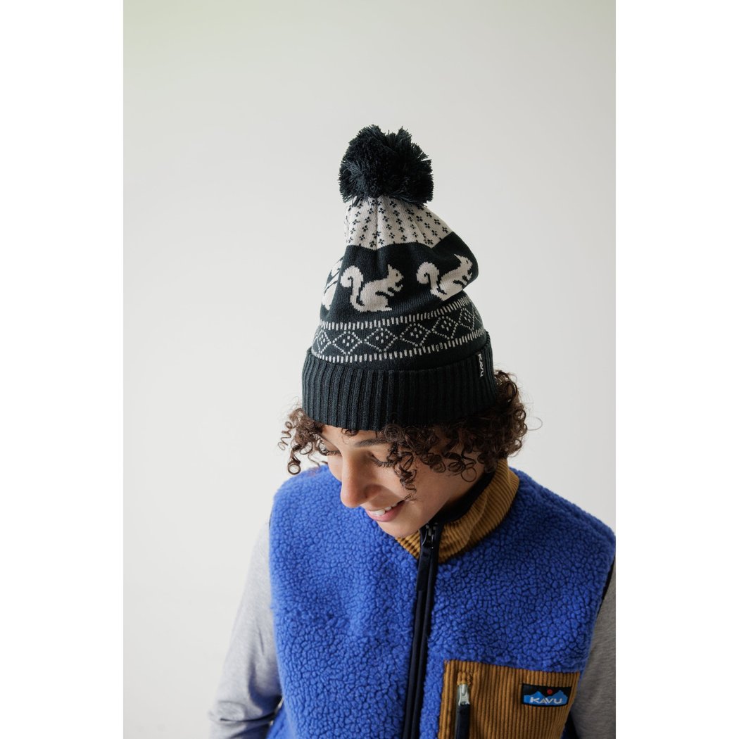 Model wearing the Kavu Herschel in Squirrely with a blue vest against a white background.